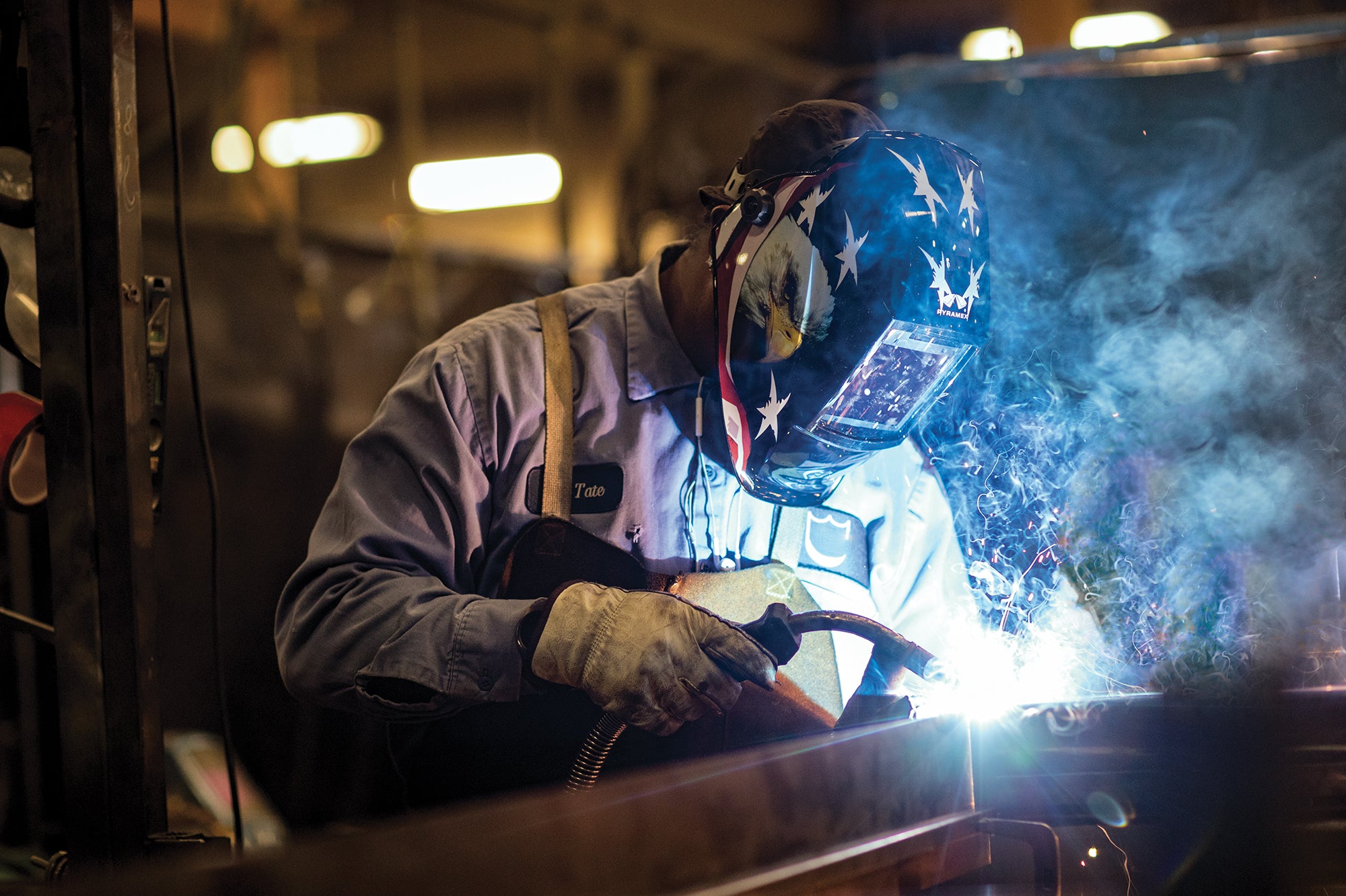 Man welding while using a Pyramex auto darkening welding helmet.