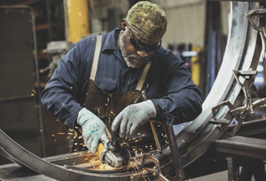 Working wear Pyramex IR eyewear and gloves while grinding metal